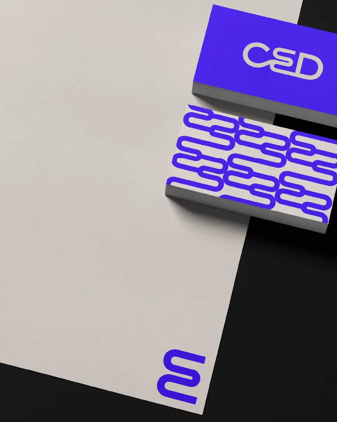 Detail shot CED stationery: letterhead bottom right with monogram, front-back business card, Klein blue cream color scheme and graphic pattern