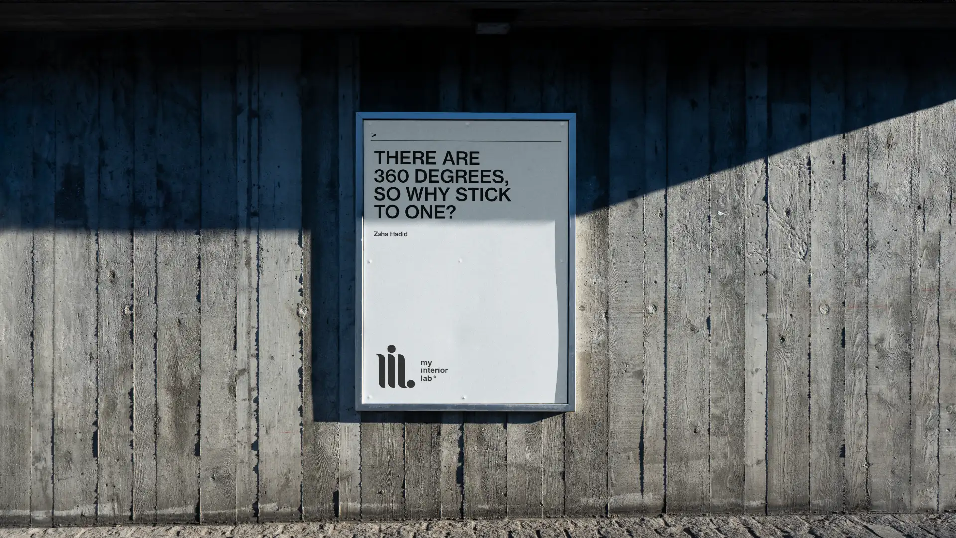 Centered My Interior Lab poster on raw concrete wall featuring "There are 360° so why stick to one?" quote, beautiful natural light, brutalist minimalist aesthetic